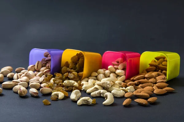 Gesunde Mischung aus Trockenfrüchten und Nüssen auf dunklem Hintergrund. Mandeln, Pistazien, Cashewkerne, Rosinen — Stockfoto