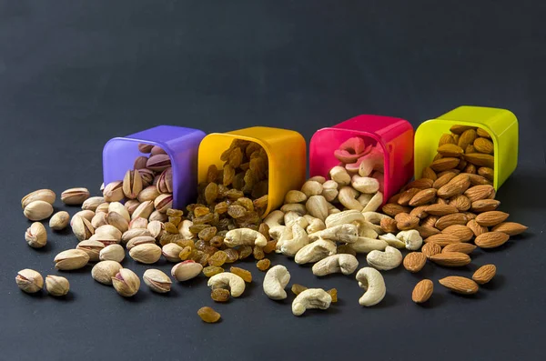 Healthy Mix Dry Fruits and Nuts on dark background. Almonds, Pistachio, Cashews, Raisins