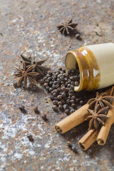 Kruiden en kruiden. Voedsel en keuken ingrediënten. Kaneelstokjes, anijssterren, zwarte peperkorrels op getextureerde achtergrond — Stockfoto