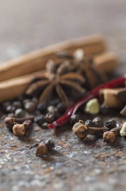 Baharatlar ve bitkiler. Yiyecek ve mutfak malzemeleri. Tarçın çubukları, anason yıldızları, karabiber, acı biber, kakule ve karanfil.
