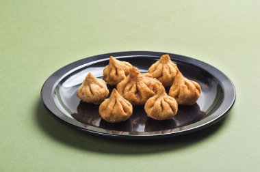 Hint yemeği: Yeşil arka planda Modak, Maharashtra Tatlı Yemek, Lord Ganesha 'nın en sevdiği tatlı, tebrik kartı tasarımı. Kopyalama alanı.