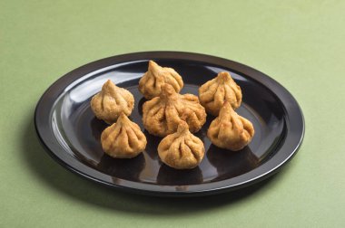 Hint yemeği: Yeşil arka planda Modak, Maharashtra Tatlı Yemek, Lord Ganesha 'nın en sevdiği tatlı, tebrik kartı tasarımı. Kopyalama alanı.