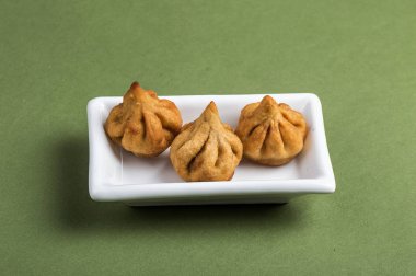 Hint yemeği: Yeşil arka planda Modak, Maharashtra Tatlı Yemek, Lord Ganesha 'nın en sevdiği tatlı, tebrik kartı tasarımı. Kopyalama alanı.