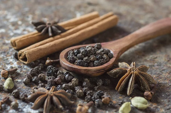 Especiarias e ervas. Comida e cozinha ingredientes. Varas de canela, estrelas de anis, pimenta preta e cardamomo em um fundo texturizado . — Fotografia de Stock