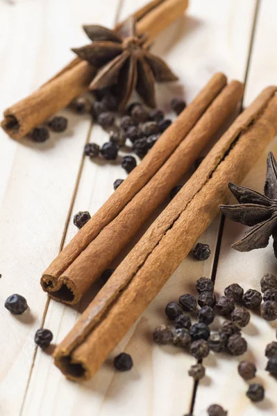 Spices and herbs. Food and cuisine ingredients. Cinnamon sticks, anise stars and black peppercorns on a wooden background. — Stock Photo, Image