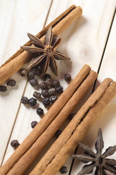 Spices and herbs. Food and cuisine ingredients. Cinnamon sticks, anise stars and black peppercorns on a wooden background. — Stock Photo, Image