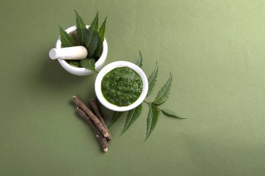 Harç ve havaneli ile tıbbi Neem yaprağı yapıştırın ve üzerinde yeşil renkli çırpı