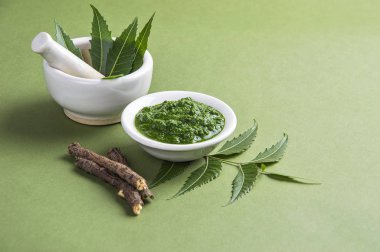 Harç ve havaneli ile tıbbi Neem yaprağı yapıştırın ve üzerinde yeşil renkli çırpı