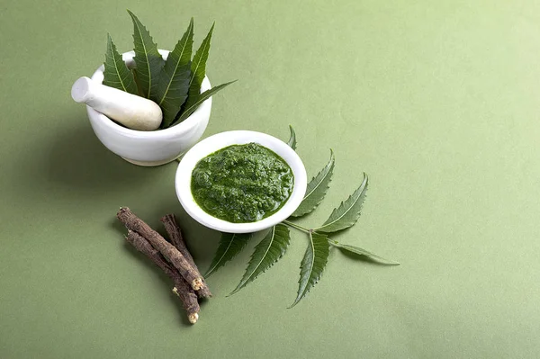 Harç ve havaneli ile tıbbi Neem yaprağı yapıştırın ve üzerinde yeşil renkli çırpı