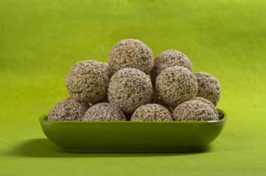 Amaranth ya da Rajgira laddu, yeşil arka planda yeşil tabakta çikolatalı laddo