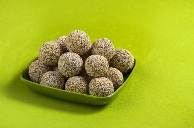 Amaranth ya da Rajgira laddu, yeşil arka planda yeşil tabakta çikolatalı laddo