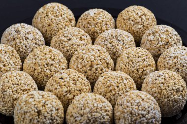 Amaranth ladoo ya da Rajgira laddu ya da siyah arka planda siyah tabakta Cholai ke laddo.