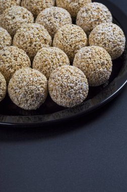 Amaranth ladoo ya da Rajgira laddu ya da siyah arka planda siyah tabakta Cholai ke laddo.