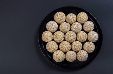 Amaranth ladoo ya da Rajgira laddu ya da siyah arka planda siyah tabakta Cholai ke laddo.