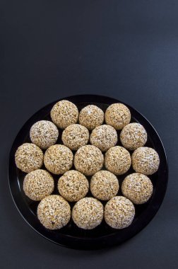 Amaranth ladoo ya da Rajgira laddu ya da siyah arka planda siyah tabakta Cholai ke laddo.