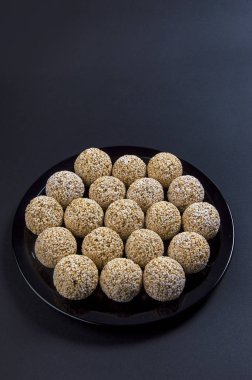 Amaranth ladoo ya da Rajgira laddu ya da siyah arka planda siyah tabakta Cholai ke laddo.