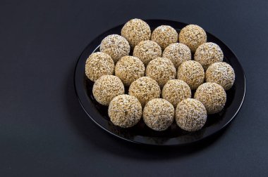 Amaranth ladoo ya da Rajgira laddu ya da siyah arka planda siyah tabakta Cholai ke laddo.