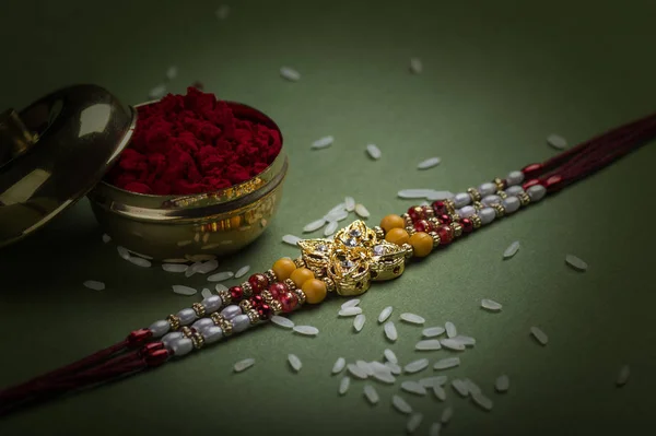 Indisk festival: Raksha Bandhan med en elegant Rakhi, Rice Grains og Kumkum. Et tradisjonelt indisk armbånd som symboliserer kjærlighet mellom brødre og søstre. – stockfoto
