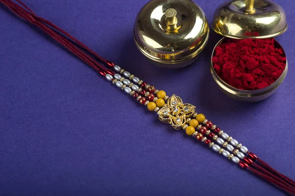 Festival indio: Raksha Bandhan fondo con un elegante Rakhi, granos de arroz y Kumkum. Una pulsera india tradicional que es un símbolo de amor entre hermanos y hermanas. —  Fotos de Stock