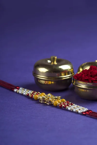 Indisk festival: Raksha Bandhan med en elegant Rakhi, Rice Grains og Kumkum. Et tradisjonelt indisk armbånd som symboliserer kjærlighet mellom brødre og søstre. – stockfoto