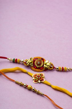 Raksha Bandhan 'ın arkaplanı zarif bir Rakhi. Geleneksel Hint bilekliği Kardeşler ve Kız Kardeşler arasındaki aşkın sembolüdür..