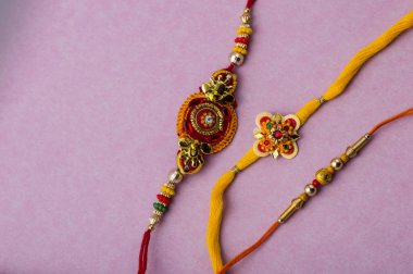 Raksha Bandhan 'ın arkaplanı zarif bir Rakhi. Geleneksel Hint bilekliği Kardeşler ve Kız Kardeşler arasındaki aşkın sembolüdür..