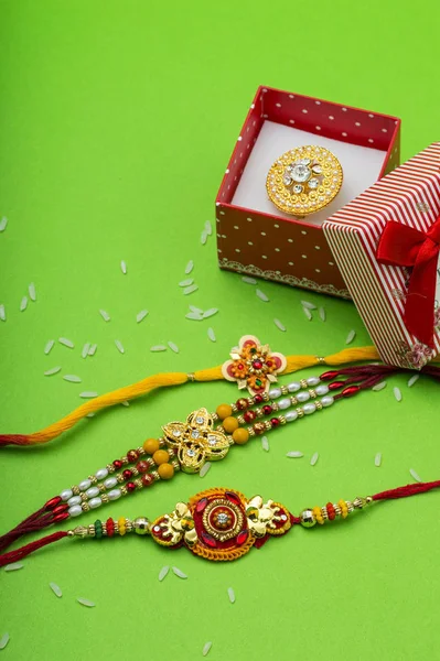 Raakhi e um presente da irmã dada pelo irmão por ocasião de Raksha Bandhan. Festa indiana Raksha Bandhan fundo com um elegante Rakhi em fundo verde . — Fotografia de Stock