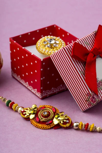 Raakhi and a gift for the sister given by brother on the occasion of Raksha Bandhan. Indian festival Raksha Bandhan background with an elegant Rakhi. — Stock Photo, Image