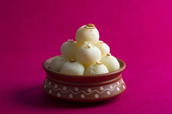 Dolce indiano o dessert Rasgulla, famoso dolce bengalese in ciotola di argilla su sfondo rosa . — Foto Stock