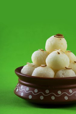 Hint Tatlısı veya Tatlısı - Rasgulla, yeşil arka planda kil kasesinde ünlü Bengali tatlısı