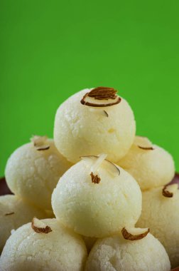 Hint Tatlısı veya Tatlısı - Rasgulla, yeşil arka planda kil kasesinde ünlü Bengali tatlısı