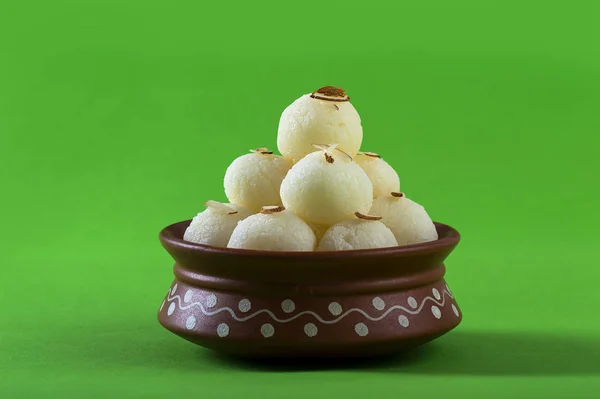 Dulce indio o postre Rasgulla, famoso dulce bengalí en tazón de arcilla sobre fondo verde — Foto de Stock