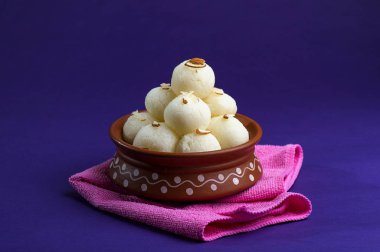 Hint Tatlısı veya Tatlısı - Rasgulla, Meşhur Bengali tatlısı Mor arka planda mavi peçete