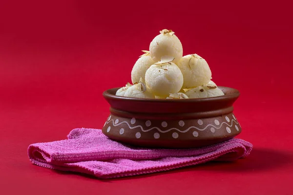 Dulce indio o postre Rasgulla, famoso dulce bengalí en tazón de barro con servilleta sobre fondo rojo — Foto de Stock