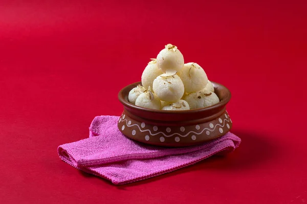 Dulce indio o postre Rasgulla, famoso dulce bengalí en tazón de barro con servilleta sobre fondo rojo — Foto de Stock