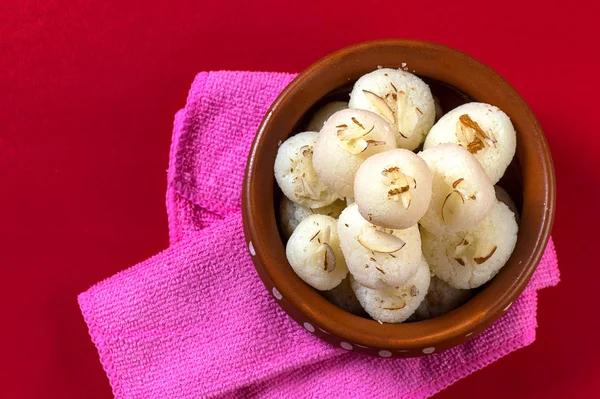 Indian Sweet or Dessert - Rasgulla, Famous Bengali sweet in clay bowl with napkin on Red Background — Stock Photo, Image
