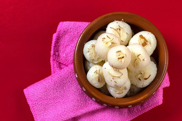 Hint Tatlısı veya Tatlısı - Rasgulla, Meşhur Bengali tatlısı, kırmızı arka planda peçeteli.