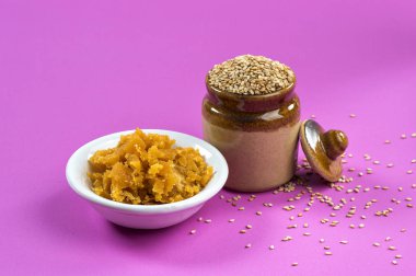 Çamurda susam tohumları, kasede jaggery, pembe arka planda