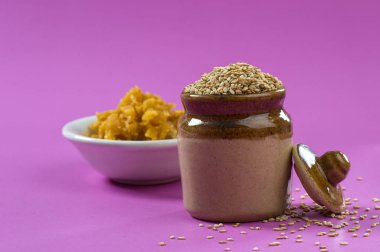 Çamurda susam tohumları, kasede jaggery, pembe arka planda