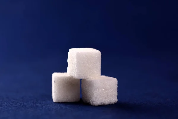 Крупный план сахарных кубиков на голубом фоне — стоковое фото
