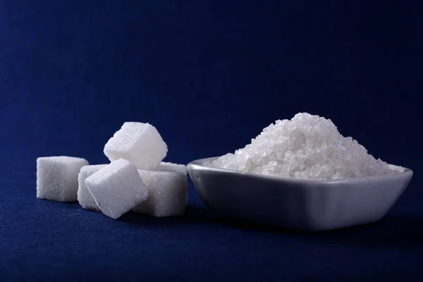 Sugar Cubes with Sugar in white plate on blue background