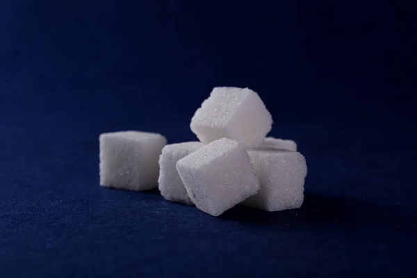 Primer plano de terrones de azúcar sobre fondo azul — Foto de Stock