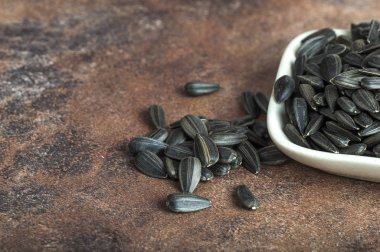Ayçiçeği tohumları (Helianthus annuus) taştan arkaplanda beyaz olarak.
