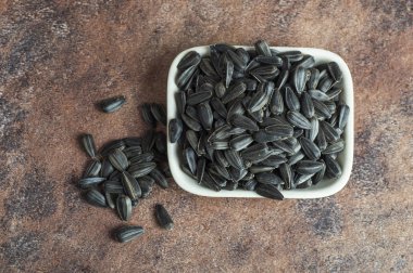 Ayçiçeği tohumları (Helianthus annuus) taştan arkaplanda beyaz olarak.