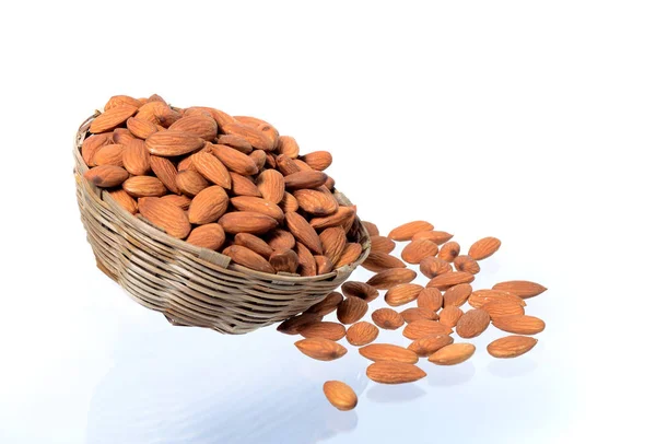 Amandelen in een houten mandje met op een witte achtergrond geïsoleerde hoop — Stockfoto