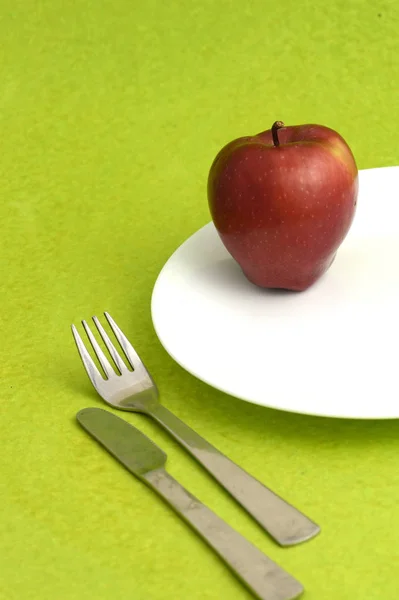 盘中美味苹果 刀叉绿色背景 — 图库照片