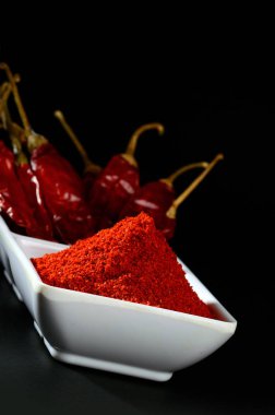 kırmızı beyaz plaka, siyah arka plan üzerine kurutulmuş biber soğuk soğuk toz