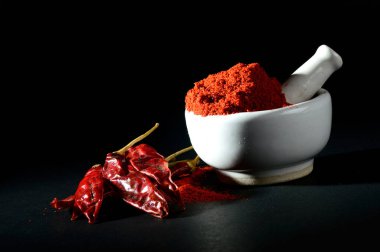 Havaneli harç ve kırmızı biber ile siyah zemin üzerine kırmızı biber tozu