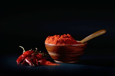 soğuk, kuru kırmızı biber siyah arka plan üzerine ahşap kase soğuk toz