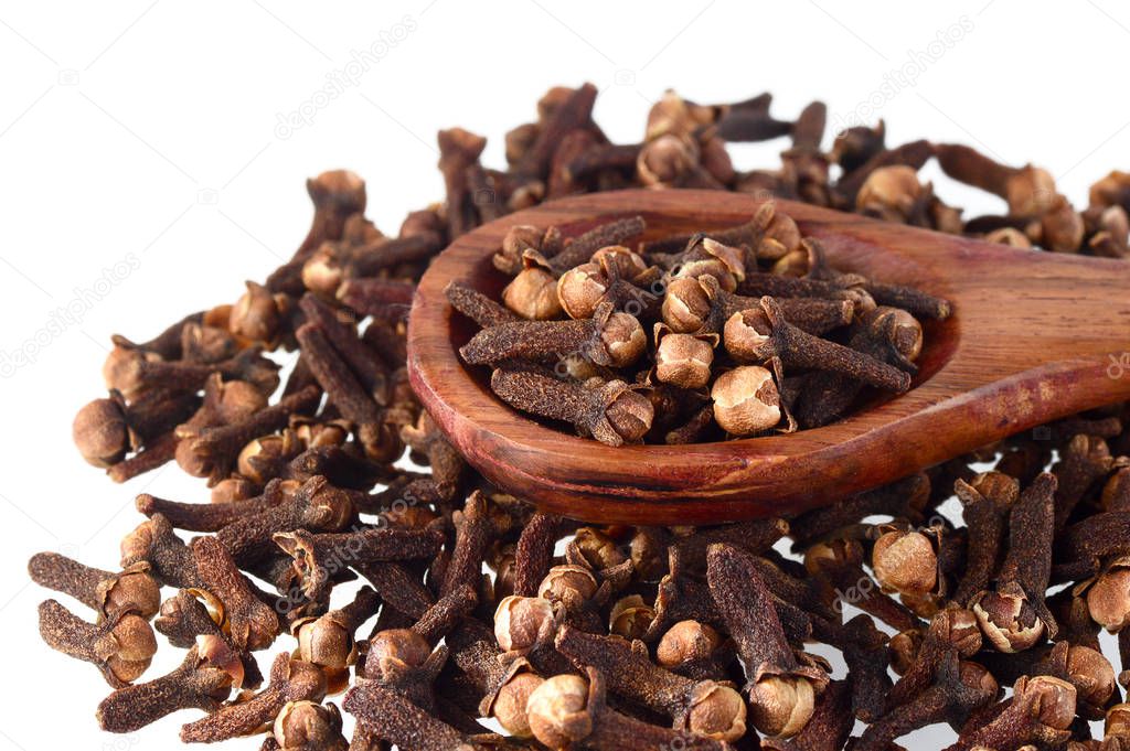 Cloves (spice) and wooden spoon close-up food background. Isolated on white background